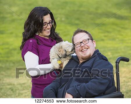 Disabled husband with his wife and their pet dog in a park in autumn; Edmonton, Alberta, Canada View Large Photo Image Stock Image - Disabled husband with his wife and their pet dog in a park in autumn; Edmonton, Alberta, Canada. Fotosearch
