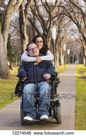 Stock Photograph - Disabled husband with his wife posing for a picture in a park in autumn; Edmonton, Alberta, Canada. Fotosearch