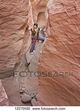 Female adventurer exploring a slot canyon; Hanksville, Utah, United States of America View Large Photo Image Stock Image - Female adventurer exploring a slot canyon; Hanksville, Utah, United States of America. Fotosearch