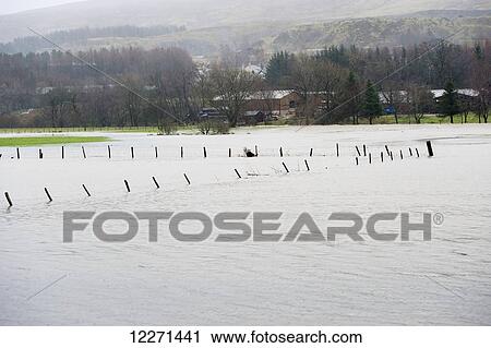 Stock Image - Fence posts sticking out over the tops of the flood water, near Thelkeld; Keswick, Cumbria, England. Fotosearch