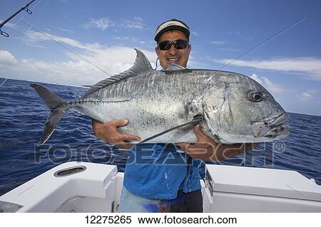 Fisherman holding a fresh caught Giant Trevally fish; Tahiti View Large Photo Image Stock Photography - Fisherman holding a fresh caught Giant Trevally fish; Tahiti. Fotosearch