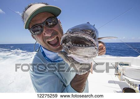 Fisherman holding a fresh caught Dogtooth Tuna (Gymnosarda unicolor); Tahiti View Large Photo Image Stock Photo - Fisherman holding a fresh caught Dogtooth Tuna (Gymnosarda unicolor); Tahiti. Fotosearch