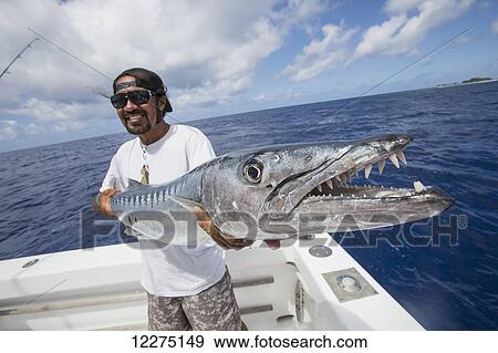 Stock Photo - Fisherman holding barracuda fish; Tahiti. Fotosearch