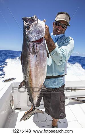Fisherman holding dogtooth tuna (Gymnosarda unicolor); Tahiti View Large Photo Image Stock Photo - Fisherman holding dogtooth tuna (Gymnosarda unicolor); Tahiti. Fotosearch
