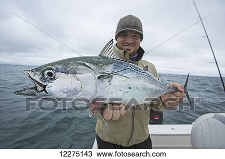 Stock Image - Fisherman holding false albacor; Cape Cod, Massachusetts, United States of America. Fotosearch