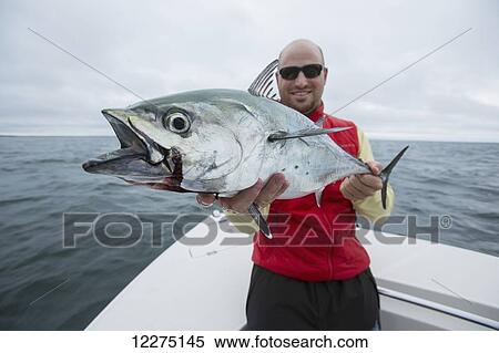 Stock Photography - Fisherman holding false albacor; Cape Cod, Massachusetts, United States of America. Fotosearch