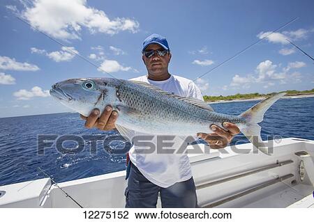 Stock Image - Fisherman with fresh caught Jobfish; Tahiti. Fotosearch