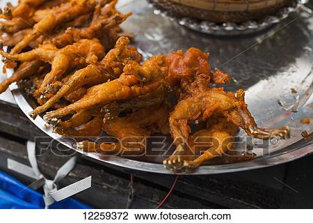 Stock Image - Fried frogs in a local market; Phnom Penh, Cambodia. Fotosearch