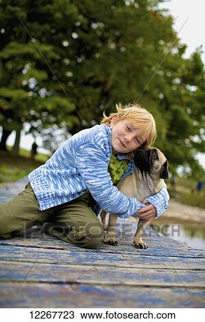 Girl hugging a dog on a dock; Picton, Ontario, Canada View Large Photo Image Stock Image - Girl hugging a dog on a dock; Picton, Ontario, Canada. Fotosearch