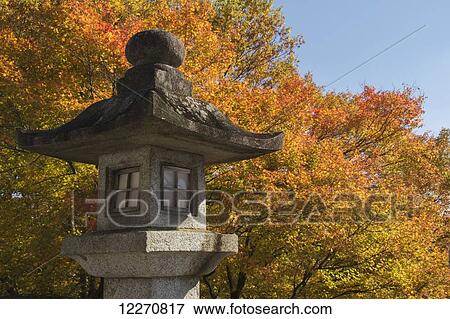 Stock Photo - Japanese shrine stone lantern against maple tree in autumn colours; Kurama, Kyoto, Japan. Fotosearch