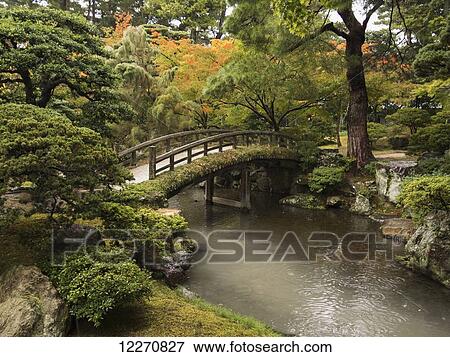 Stock Photo - Japanese stone bridge across a stream in a park; Kyoto, Japan. Fotosearch