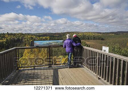 Mature couple overlooking Sunday Creek from the Algonquin Park visitor centre observation deck on a sunny afternoon in autumn; Ontario, Canada View Large Photo Image Stock Image - Mature couple overlooking Sunday Creek from the Algonquin Park visitor centre observation deck on a sunny afternoon in autumn; Ontario, Canada. Fotosearch