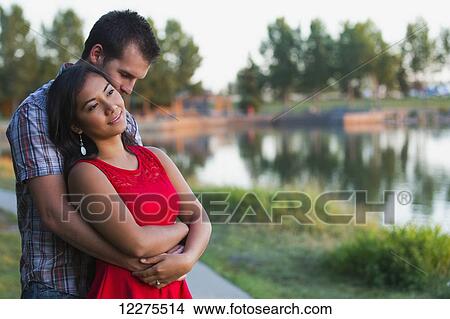 Mixed race couple spending quality time together in a park in autumn; St. Albert, Alberta, Canada View Large Photo Image Picture - Mixed race couple spending quality time together in a park in autumn; St. Albert, Alberta, Canada. Fotosearch