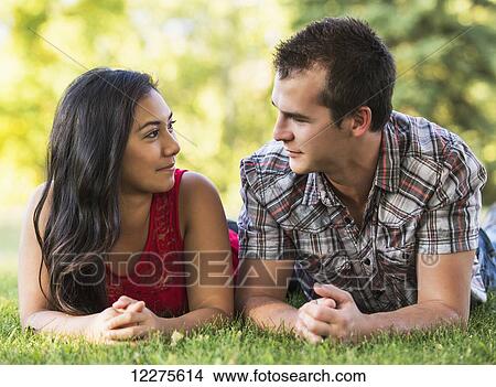 Mixed race couple spending quality time together in a park in autumn; St. Albert, Alberta, Canada View Large Photo Image Picture - Mixed race couple spending quality time together in a park in autumn; St. Albert, Alberta, Canada. Fotosearch