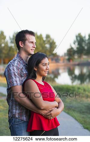 Picture - Mixed race couple spending quality time together in a park in autumn; St. Albert, Alberta, Canada. Fotosearch
