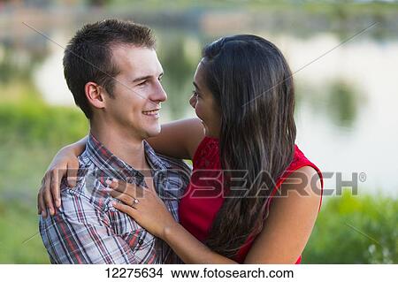 Mixed race couple spending quality time together in a park in autumn; St. Albert, Alberta, Canada View Large Photo Image Picture - Mixed race couple spending quality time together in a park in autumn; St. Albert, Alberta, Canada. Fotosearch