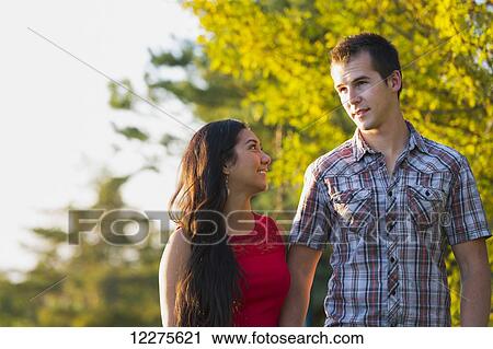Stock Image - Mixed race couple spending quality time together in a park in autumn; St. Albert, Alberta, Canada. Fotosearch