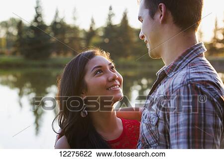 Stock Image - Mixed race couple spending quality time together in a park in autumn; St. Albert, Alberta, Canada. Fotosearch