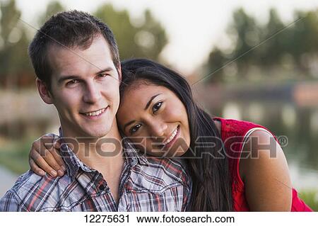 Stock Image - Mixed race couple spending quality time together in a park in autumn; St. Albert, Alberta, Canada. Fotosearch
