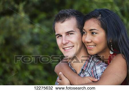 Mixed race couple spending quality time together in a park in autumn; St. Albert, Alberta, Canada View Large Photo Image Stock Image - Mixed race couple spending quality time together in a park in autumn; St. Albert, Alberta, Canada. Fotosearch