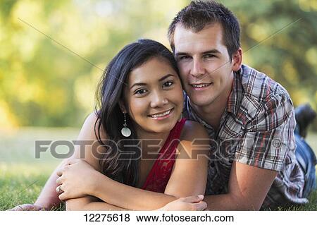 Stock Photo - Mixed race couple spending quality time together in a park in autumn; St. Albert, Alberta, Canada. Fotosearch
