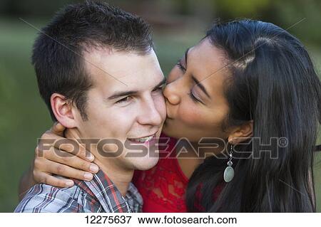 Stock Photo - Mixed race couple spending quality time together in a park in autumn; St. Albert, Alberta, Canada. Fotosearch