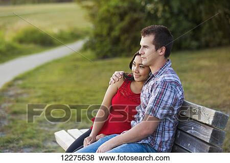Stock Photo - Mixed race couple spending quality time together in a park in autumn; St. Albert, Alberta, Canada. Fotosearch