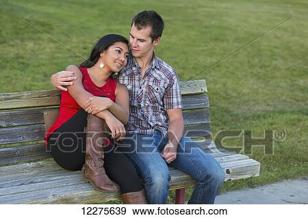 Stock Photo - Mixed race couple spending quality time together in a park in autumn; St. Albert, Alberta, Canada. Fotosearch