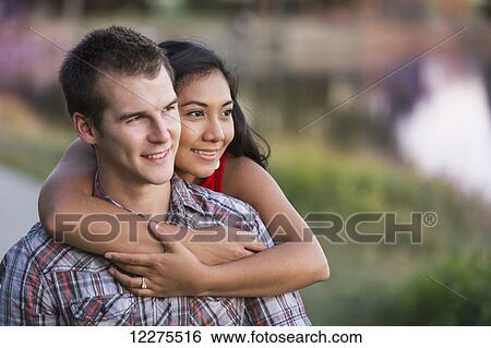 Stock Photograph - Mixed race couple spending quality time together in a park in autumn; St. Albert, Alberta, Canada. Fotosearch