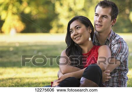 Stock Photograph - Mixed race couple spending quality time together in a park in autumn; St. Albert, Alberta, Canada. Fotosearch