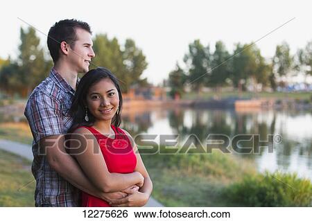 Stock Photograph - Mixed race couple spending quality time together in a park in autumn; St. Albert, Alberta, Canada. Fotosearch