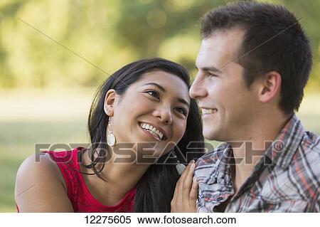 Stock Photography - Mixed race couple spending quality time together in a park in autumn; St. Albert, Alberta, Canada. Fotosearch