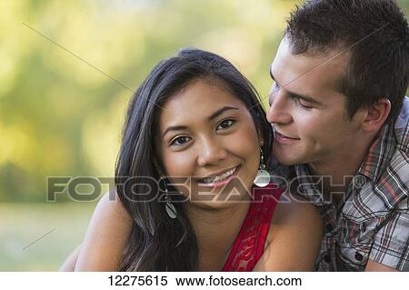 Stock Photography - Mixed race couple spending quality time together in a park in autumn; St. Albert, Alberta, Canada. Fotosearch