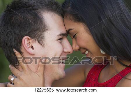 Stock Photography - Mixed race couple spending quality time together in a park in autumn; St. Albert, Alberta, Canada. Fotosearch