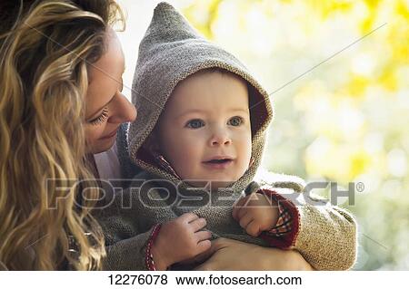 Stock Photo - Mother and son cuddling in a park in autumn; Langley, British Columbia, Canada. Fotosearch