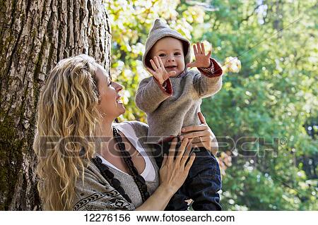 Mother holding her son outdoors in a park in autumn; Langley, British Columbia, Canada View Large Photo Image Stock Photograph - Mother holding her son outdoors in a park in autumn; Langley, British Columbia, Canada. Fotosearch