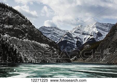 Stock Photography - Mountains and frozen lake in winter, Bow Valley Wildland; Alberta, Canada. Fotosearch