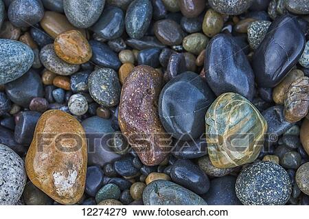 Stock Photo - Multi-coloured rocks line the shoreline at Agate Beach, Naikoon Provincial Park, Haida Gwaii; British Columbia, Canada. Fotosearch