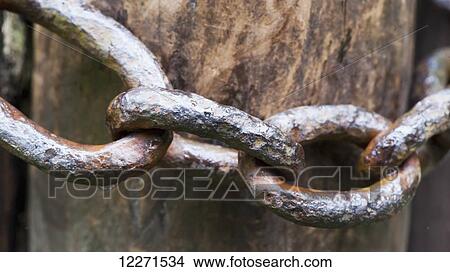 Old metal chain around a gatepost; United Kingdom View Large Photo Image Picture - Old metal chain around a gatepost; United Kingdom. Fotosearch