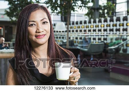 Portrait of a businesswoman enjoying a break at a coffee shop in a shopping mall; St. Albert, Alberta, Canada View Large Photo Image Stock Image - Portrait of a businesswoman enjoying a break at a coffee shop in a shopping mall; St. Albert, Alberta, Canada. Fotosearch