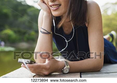 Portrait of a young chinese woman listening to music; Xiamen, Fujian province, China View Large Photo Image Picture - Portrait of a young chinese woman listening to music; Xiamen, Fujian province, China. Fotosearch
