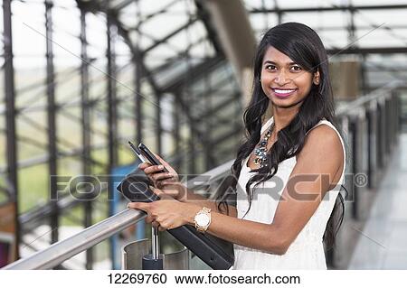 Stock Image - Portrait of a young professional woman in a downtown setting; Edmonton, Alberta, Canada. Fotosearch