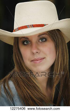 Stock Photograph - Portrait of a young woman wearing a cowboy hat; United States of America. Fotosearch