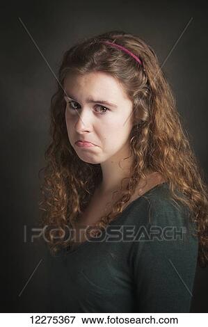 Stock Photo - Portrait of a young woman with a sad face; United States of America. Fotosearch