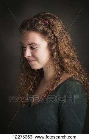 Portrait of a young woman with curly brunette hair looking down; United States of America View Large Photo Image Stock Image - Portrait of a young woman with curly brunette hair looking down; United States of America. Fotosearch