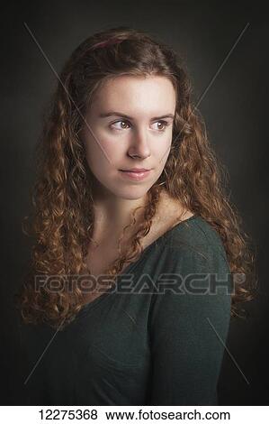 Stock Photo - Portrait of a young woman with long curly hair; United States of America. Fotosearch