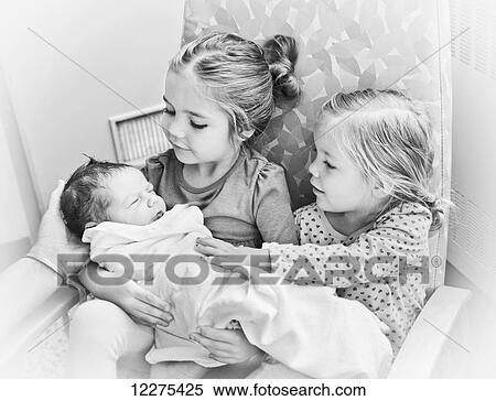 Stock Photography - Portrait of two sisters holding newborn baby brother; Vancouver, British Columbia, Canada. Fotosearch