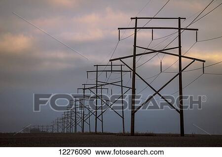 Stock Image - Power lines with a cloudy sky at sunset; Saskatchewan, Canada. Fotosearch