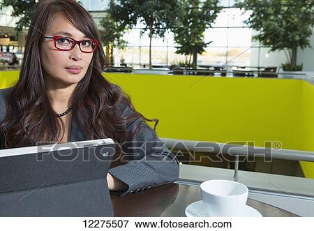 Professional businesswoman using a tablet in a lounge area; St. Albert, Alberta, Canada View Large Photo Image Stock Photo - Professional businesswoman using a tablet in a lounge area; St. Albert, Alberta, Canada. Fotosearch