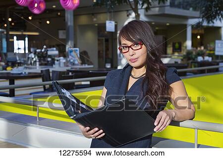 Professional businesswoman with a portfolio in a shopping centre; St. Albert, Alberta, Canada View Large Photo Image Picture - Professional businesswoman with a portfolio in a shopping centre; St. Albert, Alberta, Canada. Fotosearch